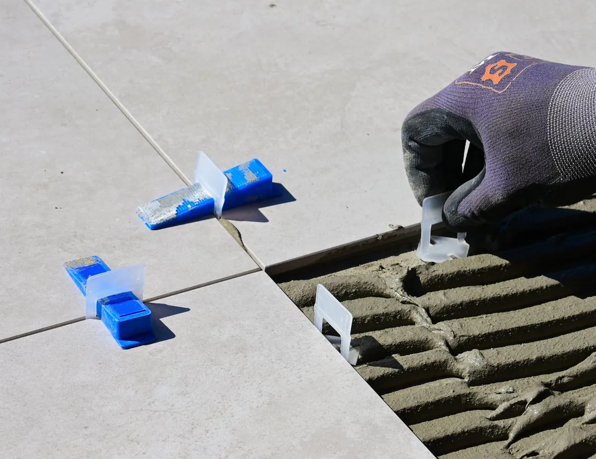Tile leveling clips and spacers aligning tile edges for a flat floor